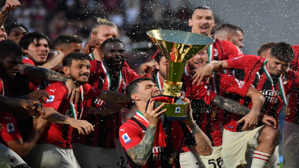 لاعبو نادي ميلان يحملون كأس الدوري الإيطالي لكرة القدم بعد التتويج به للمرة الأولى منذ 11 عاما. 22 أيار/مايو 2022. (أ ف ب)