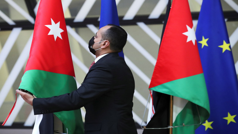 صورة أرشيفية لأردني يعدل العلم الوطني قبل زيارة جلالة الملك عبد الله الثاني إلى المجلس الأوروبي في بروكسل. 05/05/2021. (رويترز)