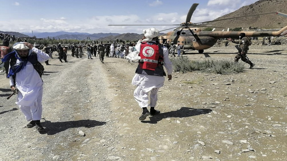 صورة نشرتها وكالة أنباء بختار التي تديرها الحكومة الأفغانية، تظهر جنودا ومسؤولين من الهلال الأحمر الأفغاني قرب طائرة هليكوبتر في منطقة ضربها زلزال. 22/06/2022. (أ ف ب)