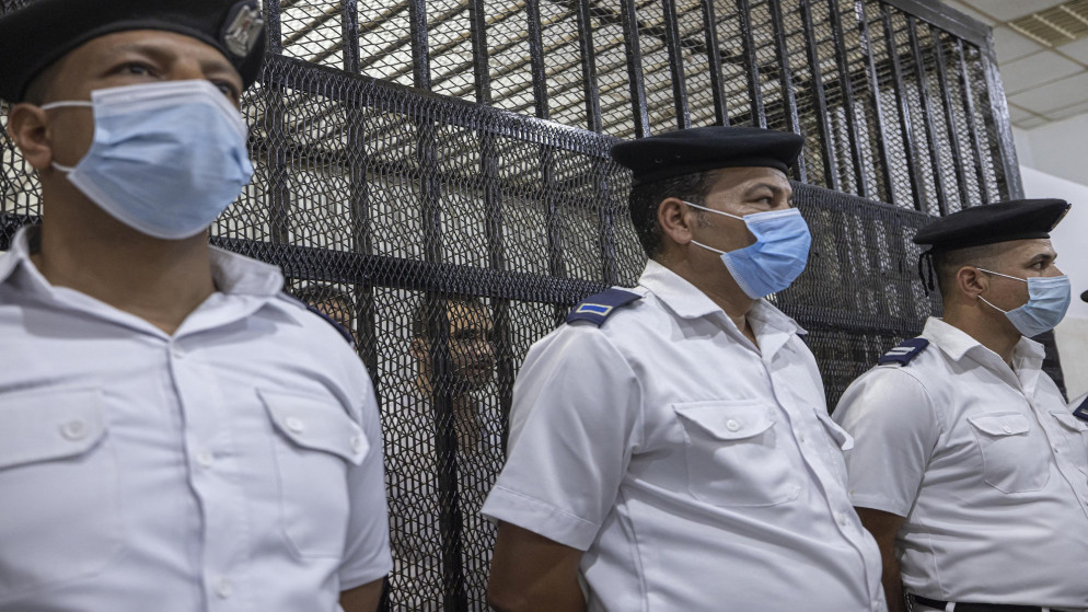 ضباط شرطة مصريون داخل محكمة المنصورة أمام صندوق المتهم بقتل طالبة في جامعة. 26 يونيو/حزيران 2022. (أ ف ب)