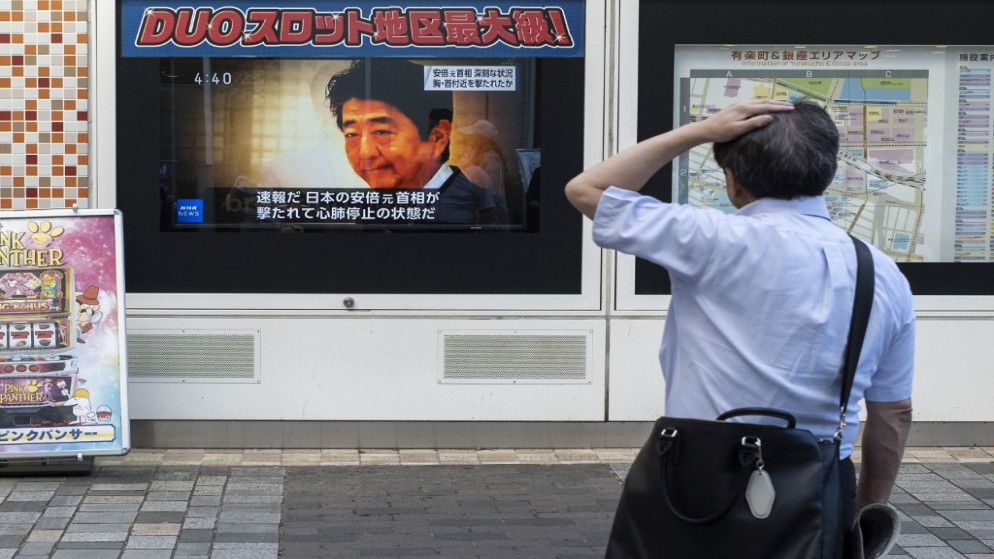 رجل ينظر إلى بث تلفزيوني يعرض أخبارا عن الهجوم على رئيس الوزراء الياباني السابق شينزو آبي، على طول أحد شوارع طوكيو، 8 تموز/يوليو 2022. (أ ف ب)