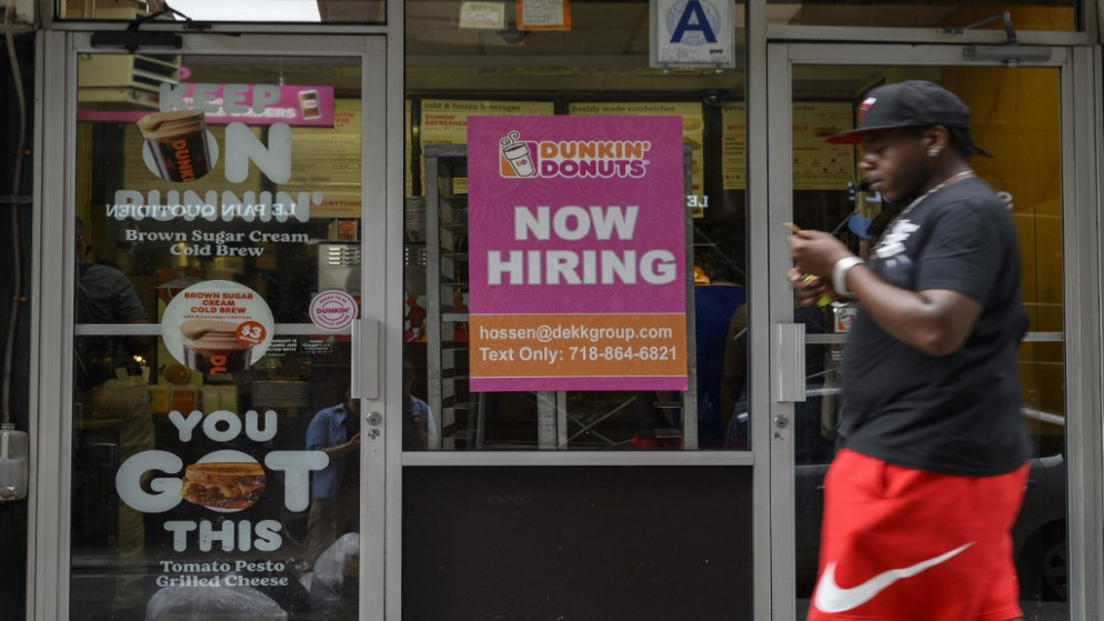 رجل يعبر أمام لافتة كتب عليها "التوظيف الآن" أمام محل تجاري في نيويورك. (أ ف ب)