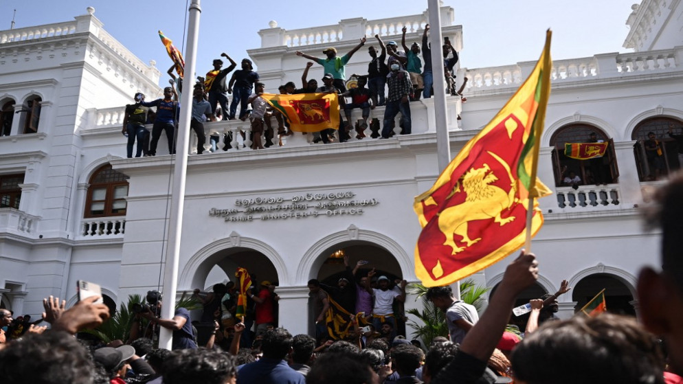 يردد المتظاهرون شعارات ويلوحون بالأعلام السريلانكية خلال مظاهرة مناهضة للحكومة داخل مبنى مكتب رئيس وزراء سريلانكا في كولومبو في 13 يوليو / تموز 2022.(أ ف ب)