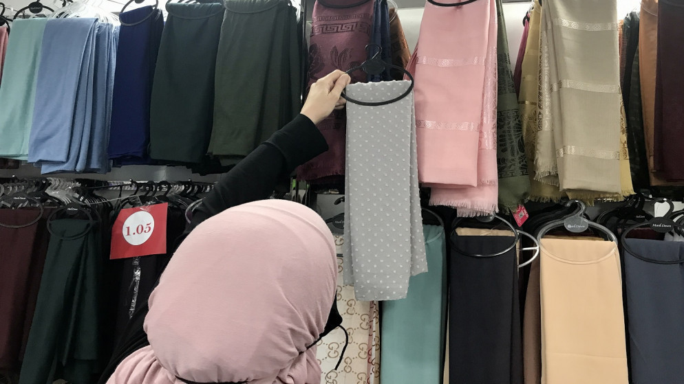 سيدة في محل ملابس بعمّان ترتدي كمامة للوقاية من فيروس كورونا. 19/7/2021.(صلاح ملكاوي /المملكة)