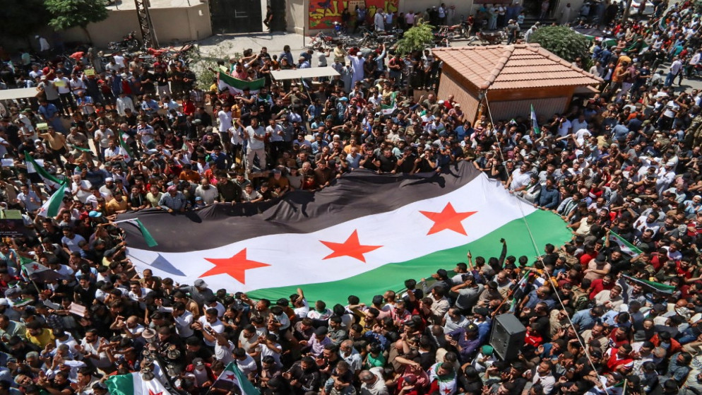 تظاهرة لسوريين يحملون علما كبيرا للمعارضة في مدينة أعزاز شمالي سوريا. 12 آب/أغسطس 2022. (أ ف ب)