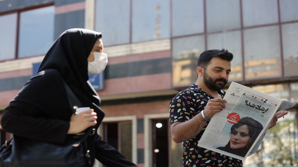 رجل يشاهد صحيفة عليها صورة مهسا أميني التي توفيت بعد أن اعتقلتها "شرطة الأخلاق"في إيران . 18 سبتمبر / أيلول 2022. (رويترز)