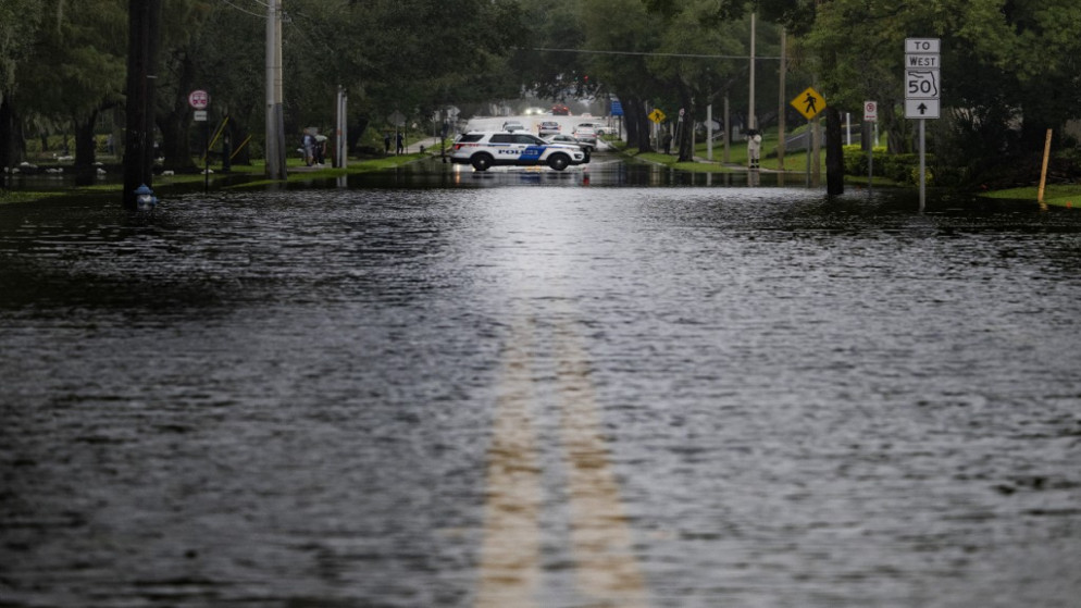 سيارة شرطة تغلق شارعًا غمرته المياه في أعقاب إعصار إيان في أورلاندو بولاية فلوريدا، 29 سبتمبر 2022. (أ ف ب)
