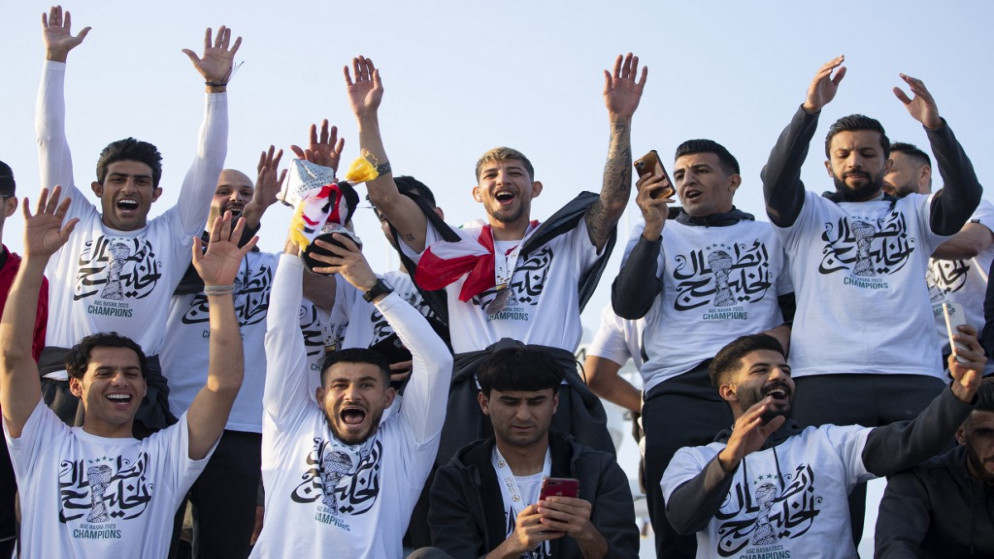 لاعبو منتخب العراق يحتفلون، على متن قارب يبحر في ممر شط العرب المائي بمدينة البصرة، بعد فوزهم بكأس الخليج العربي، 20 يناير 2023. (أ ف ب)