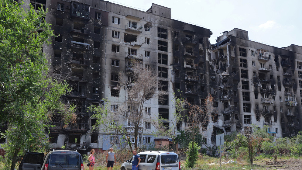 أشخاص يقفون أمام مبنى سكني تضرر بشدة خلال الحرب في أوكرانيا في مدينة سيفيرودونيتسك في منطقة لوغانسك، أوكرانيا، 1 تموز/يوليو 2022. (رويترز)