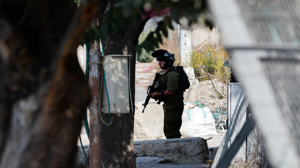 جندي تابع لقوات الاحتلال الإسرائيلي يقف عند مدخل الخليل في الضفة الغربية المحتلة.  (رويترز)