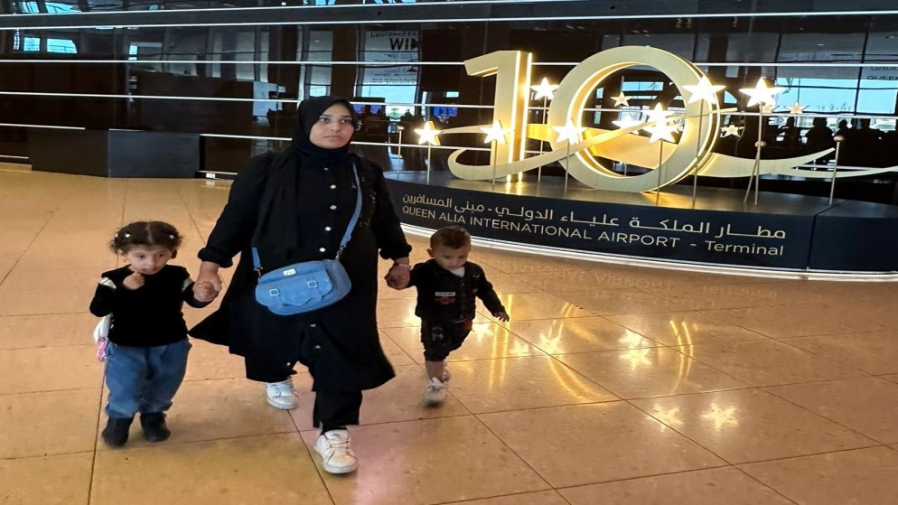 فلسطينية وطفليها الأردنيين يصلون مطار الملكة علياء الدولي بعد إجلائهم من قطاع غزة. (المملكة)