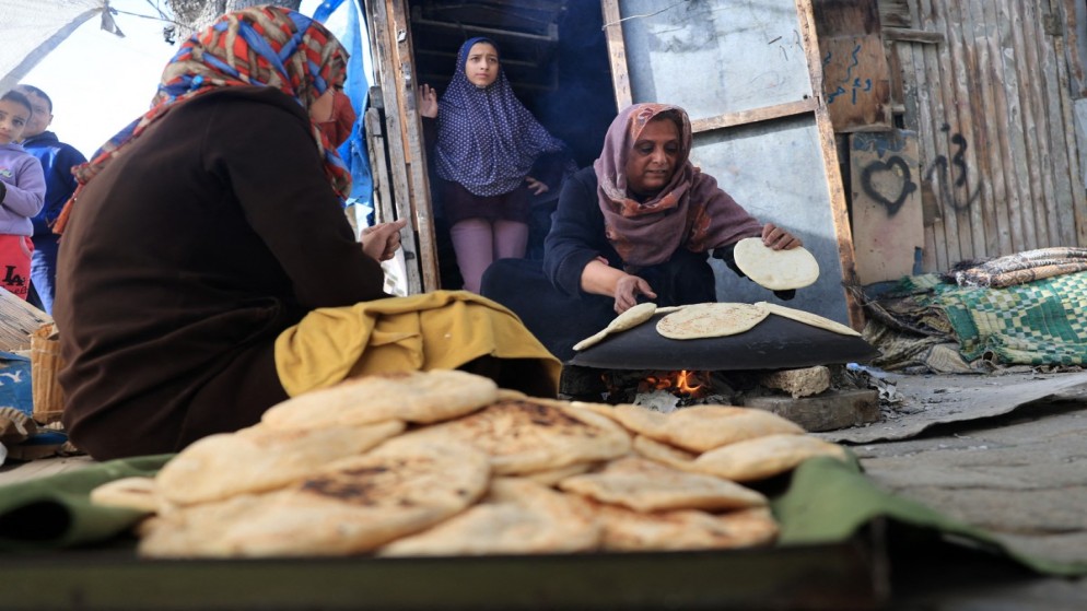 نساء يخبزن الخبز باستخدام موقد حطب مؤقت في رفح بجنوب قطاع غزة .25 نوفمبر/تشرين الثاني 2023. (ا ف ب)