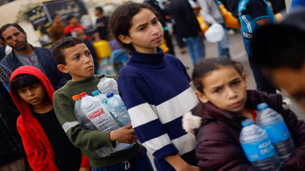 أطفال فلسطينيون يصطفون للحصول على المياه، في رفح بجنوب قطاع غزة، 5 ديسمبر 2023. (رويترز)