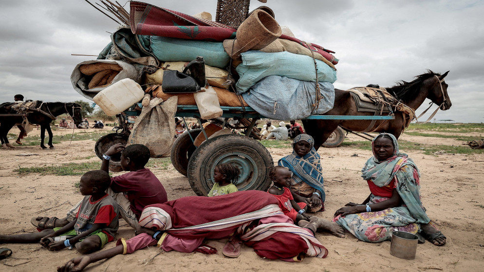 عائلة سودانية فرت من الصراع في مورني في منطقة دارفور في السودان، تجلس بجانب ممتلكاتها عند عبور الحدود بين السودان وتشاد في أدري في تشاد، 26 تموز/يوليو 2023. (رويترز)