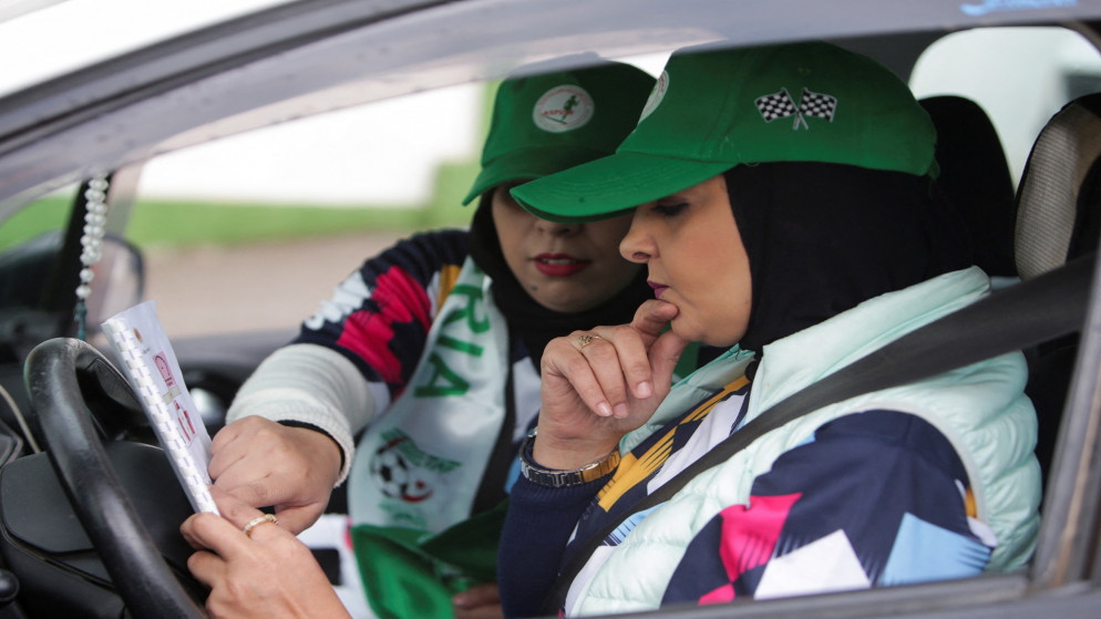 نادية خليفة، المشاركة في سباق السيارات الدولي في الجزائر تجلس مع مساعدتها أثناء قراءتهما لكتاب دليل السباق في نسخته الثانية. 26/01/2023. (رمزي بودينا/ رويترز)