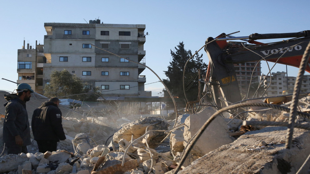 عاملا إنقاذ عند مبنى منهار عقب زلزال في اللاذقية، 9 شباط/فبراير 2023. (رويترز)