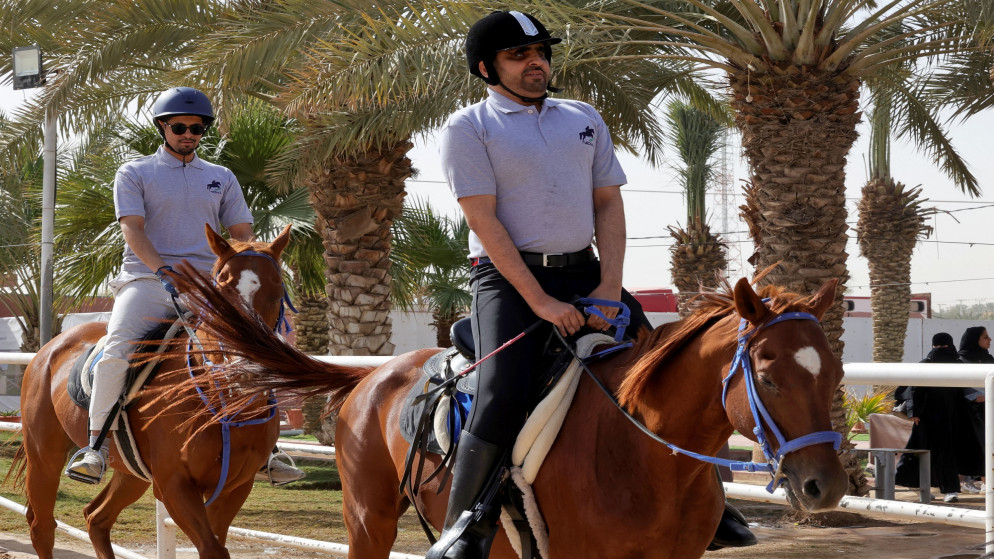 الكفيفان السعوديان الفارس بدر الشراري (يمين) وعبد الرحمن العتيبي يمتطيان الخيول خلال دورة تدريبية في مركز فروسية شرقي الرياض. 08/02/2023. (أ ف ب)