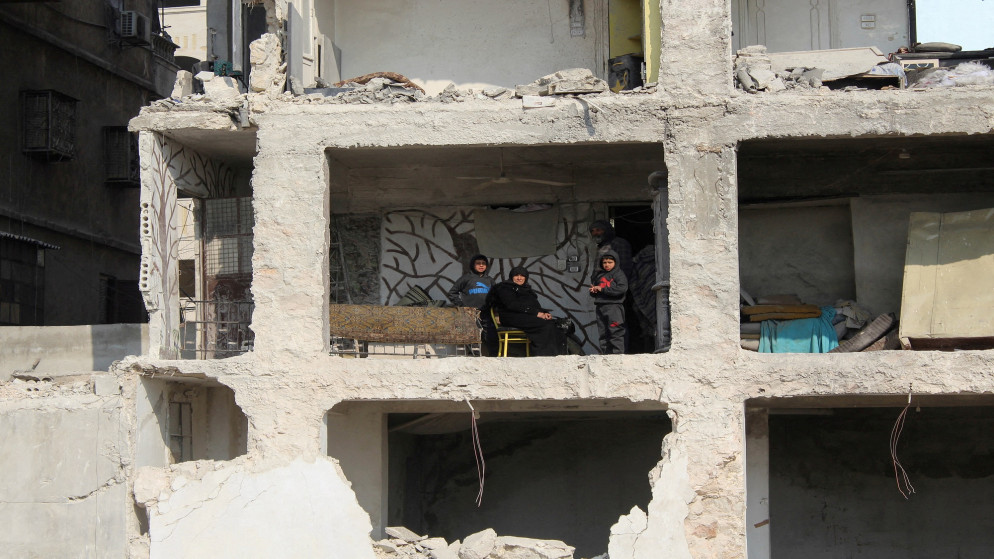 عائلة سورية تجلس في منزل متضرر جزئيا في أعقاب الزلزال المدمر في حلب شمالي سوريا. 13 شباط/فبراير 2023. (فراس مقدسي / أ ف ب)