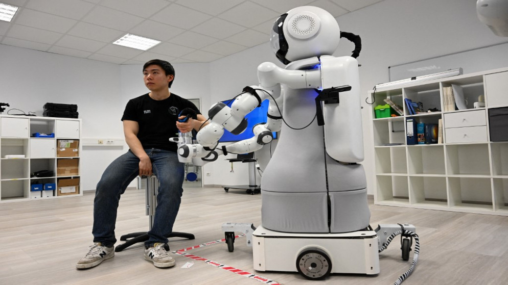 شخص يجلس بجانب الروبوت "غارمي" في معهد ميونيخ للروبوتات والذكاء الآلي. (أ ف ب)