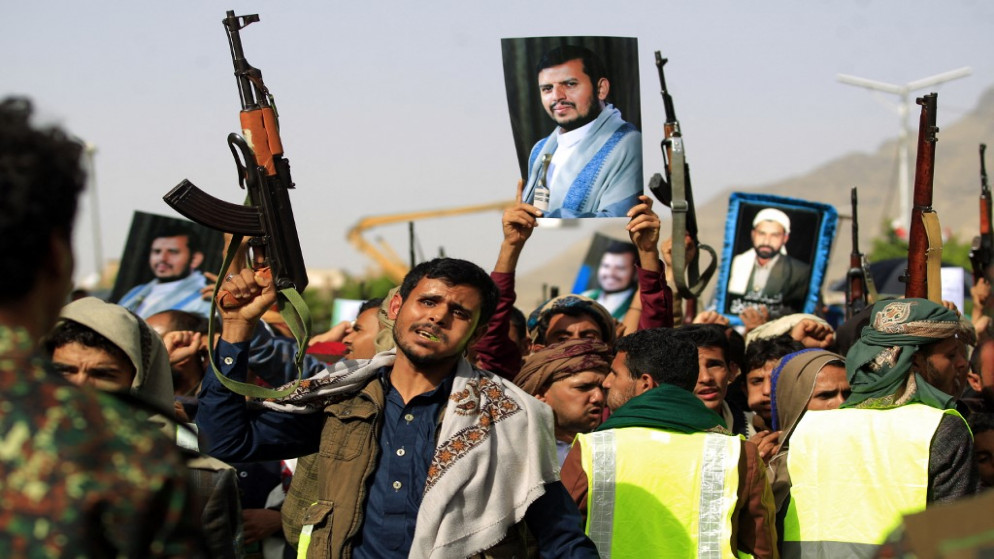 مقاتلون موالون للحوثيين خلال تجمع لهم في صنعاء وهم يرفعون صورة زعيمهم عبدالملك الحوثي. (أ ف ب)