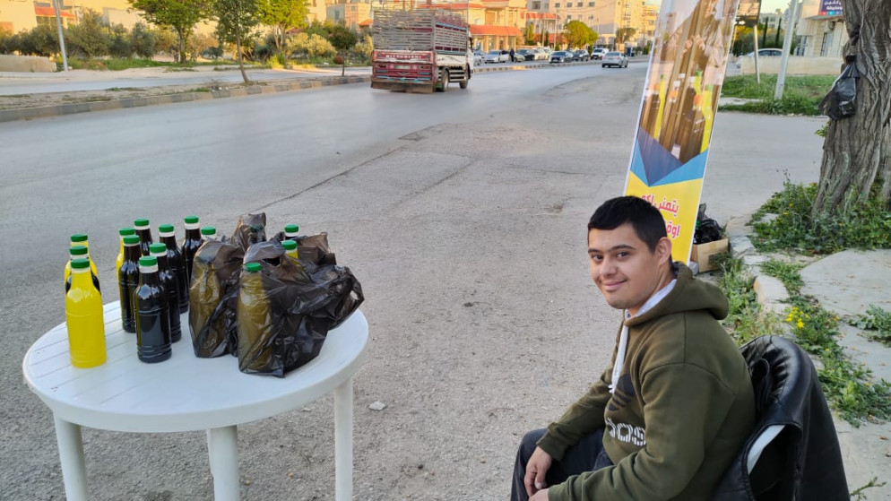 الشاب هيثم قرب "طاولة" بيع عصير التمر الهندي في مدينة إربد. (المملكة)