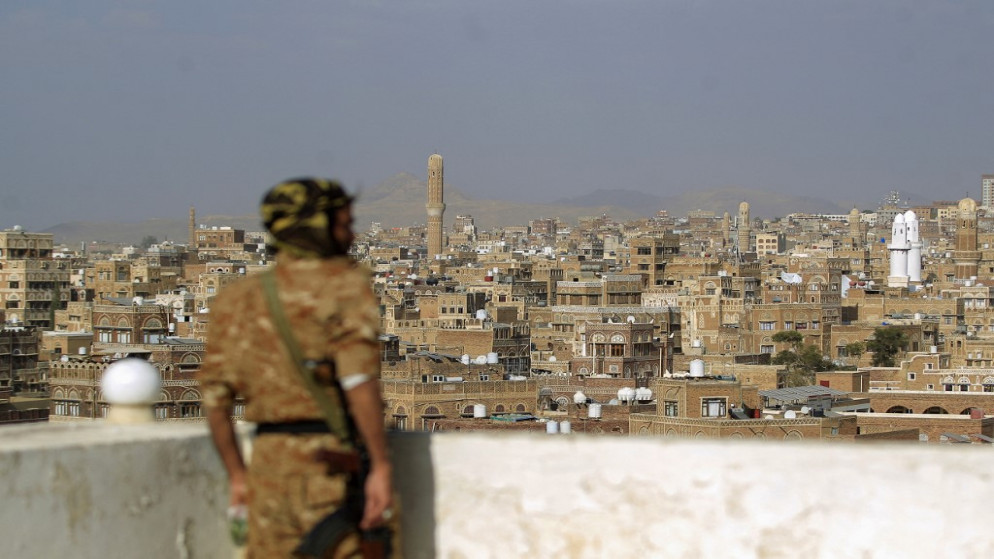 مقاتل في جماعة الحوثي وأمامه منظر عام لصنعاء. (أ ف ب)