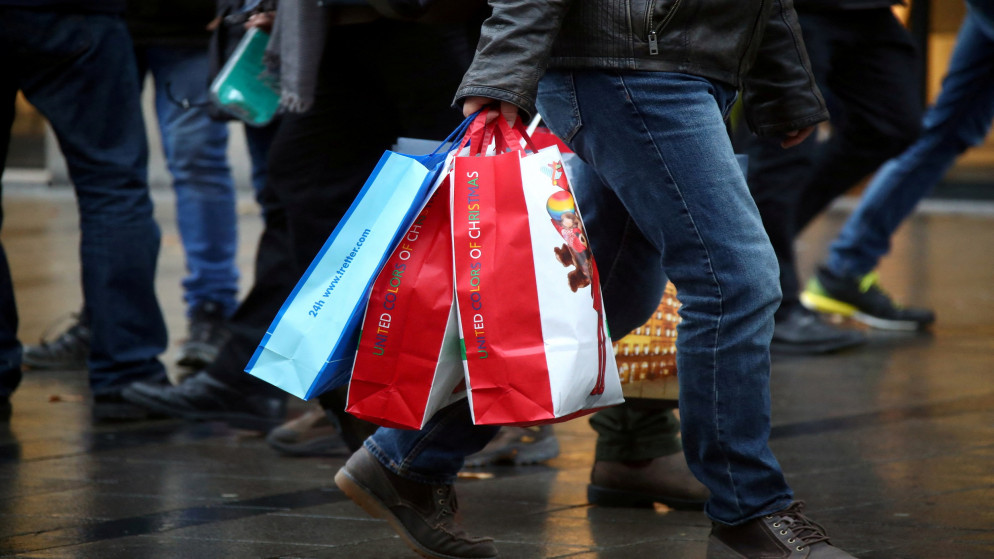 شخص يحمل أكياس تسوق في شارع رئيسي في ميونخ. (رويترز)