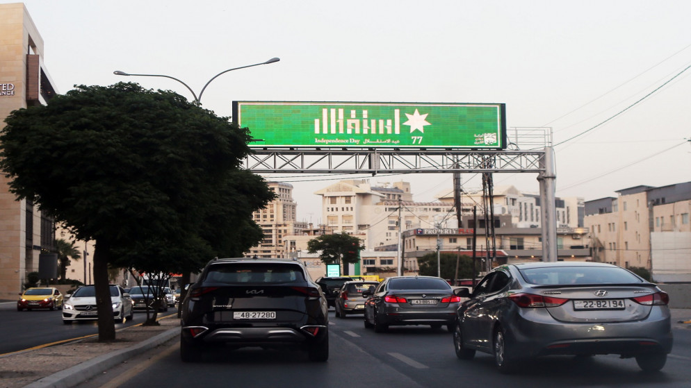 شارع في العاصمة عمان ويظهر لافتة عليها شعار عيد الاستقلال الـ 77. (صلاح ملكاوي/المملكة)