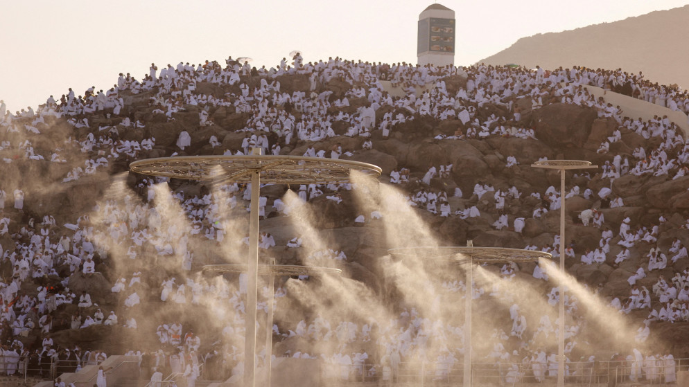 حجاج يقفون على جبل عرفات وسط أجواء شديدة الحرارة. (رويترز)