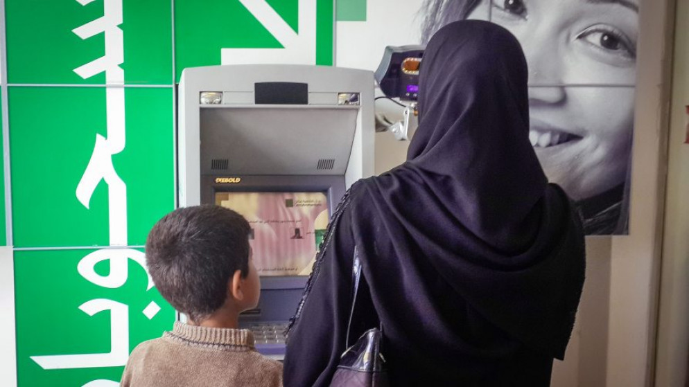 لاجئة تحاول سحب النقود من جهاز صرف آلي. (UNHCR)