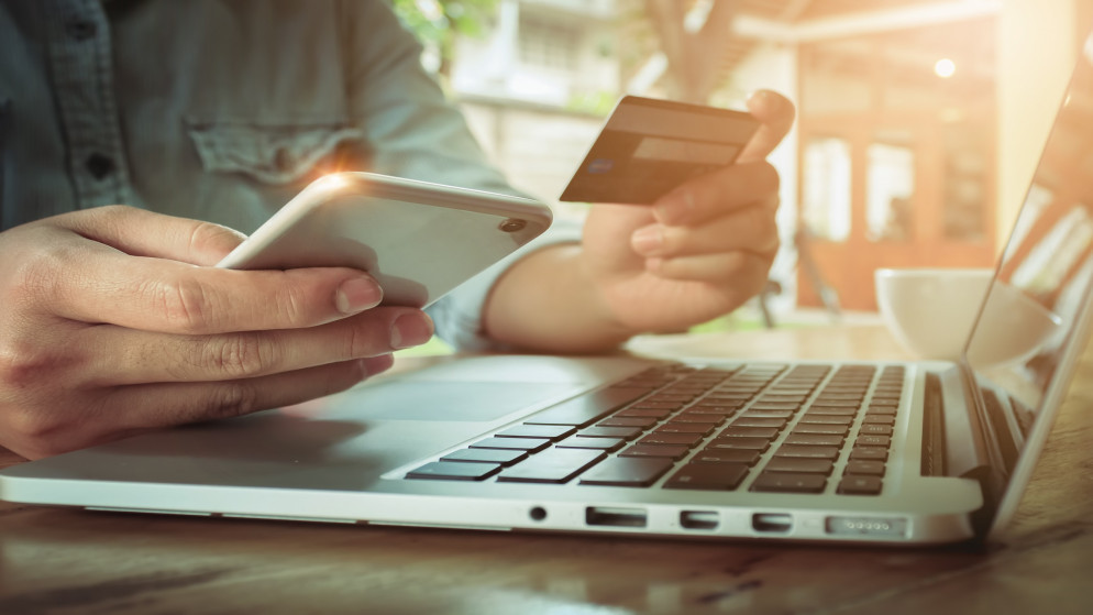 صورة توضيحية لشخص يدفع ثمن مشترياته عبر نظام التجارة الإلكترونية. (Shutterstock)