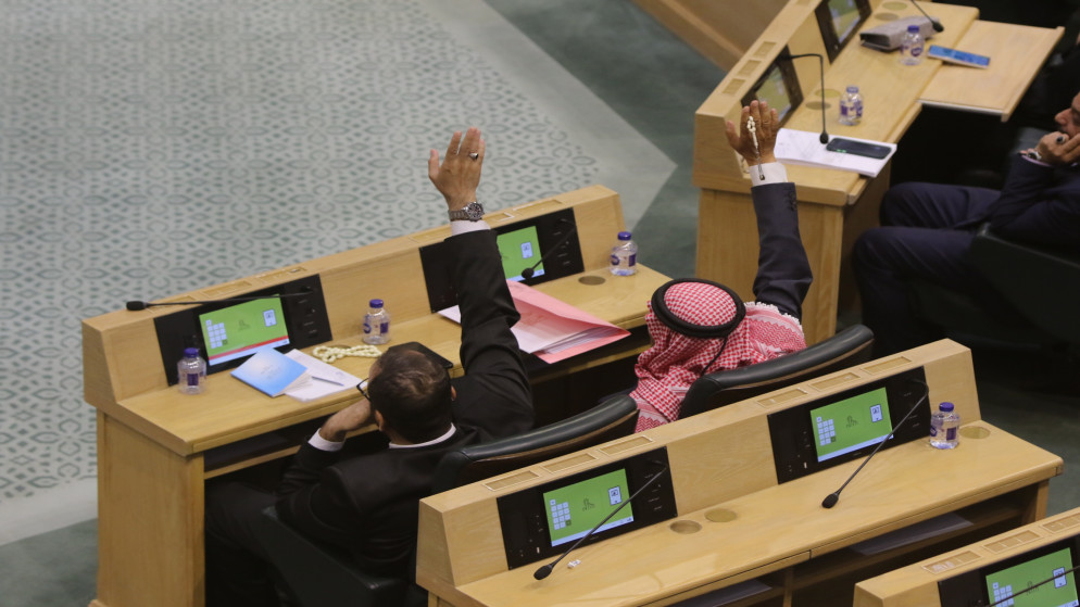 نائبان خلال التصويت على أحد مشاريع القوانين المدرجة في الدورة الاستثنائية. (صلاح ملكاوي)