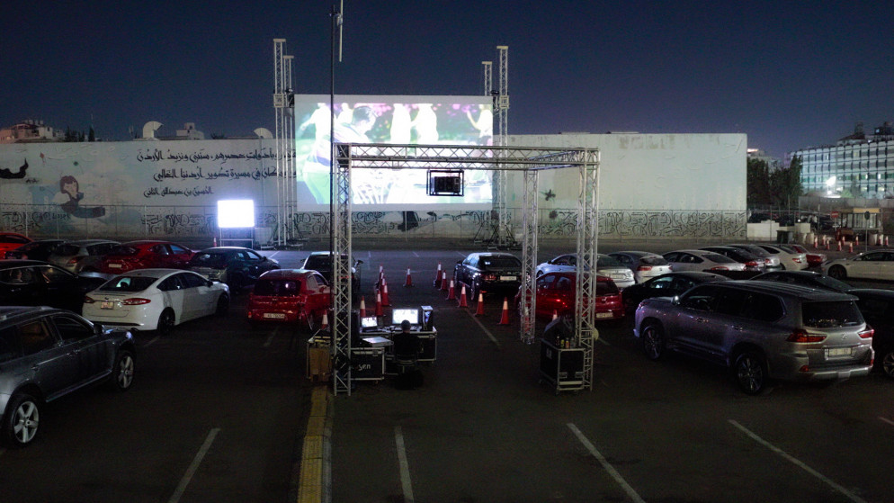 صورة لأشخاص داخل مركباتهم وهم يشاهدون فيلم "بعد الشمس" في ساحة في الهواء الطلق في عمّان. (عمر الدجاني/ المملكة)