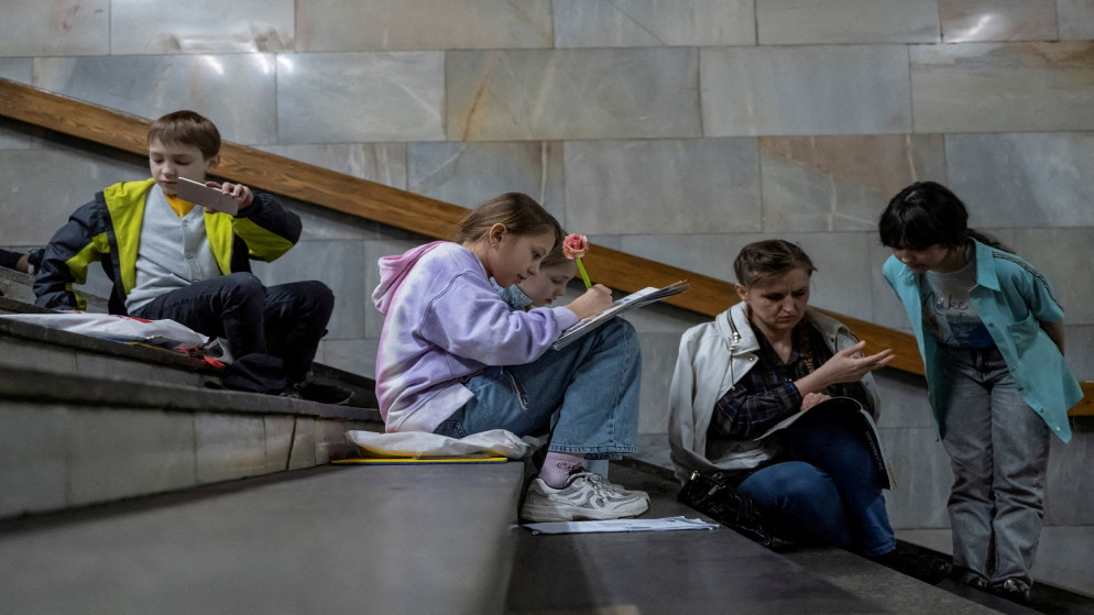 طلاب يحضرون درسًا وهم يحتمون داخل محطة مترو أثناء تنبيه بالغارة الجوية، وسط هجوم روسي على أوكرانيا، في كييف، أوكرانيا، 3 مايو 2023. (رويترز)
