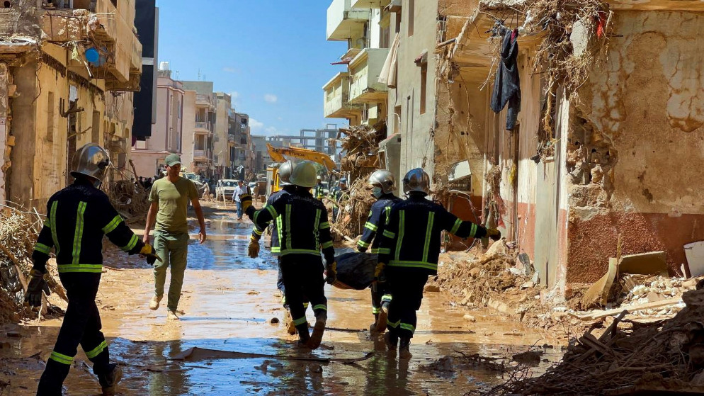 فريق إنقاذ مصري يحمل جثمان شخص توفي نتيجة الفيضانات في مدينة درنة في شرق ليبيا. (رويترز)