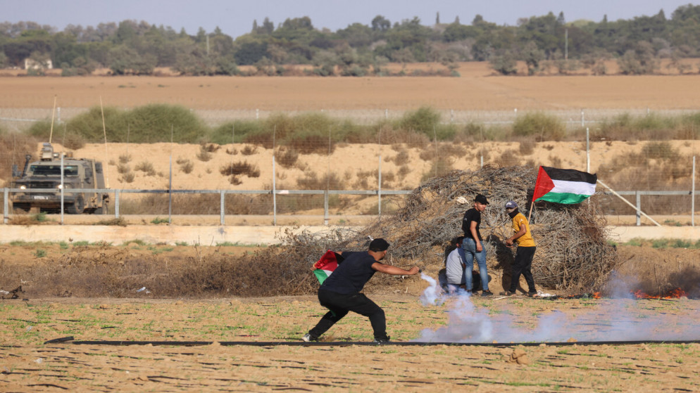 متظاهر فلسطيني يرمي قنبلة غاز مسيل للدموع على القوات الإسرائيلية خلال اشتباكات على طول الحدود مع غزة، شرق بلدة خان يونس في جنوب قطاع غزة، 15 أيلول. (أ ف ب)