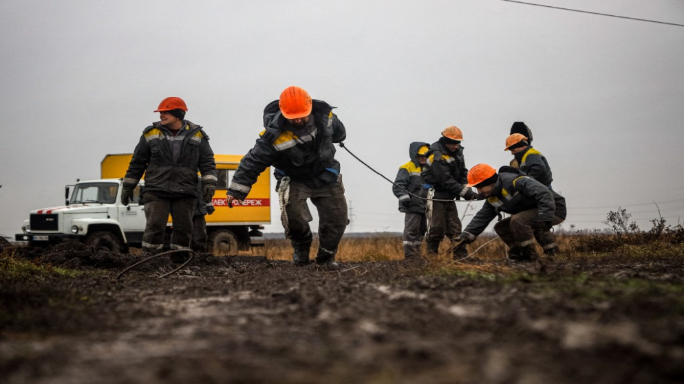 عمال يصلحون خطوط الكهرباء عالية الجهد التي قطعتها ضربات صاروخية حديثة بالقرب من أوديسا .7 كانون الأول/ ديسمبر 2022. (أ ف ب)