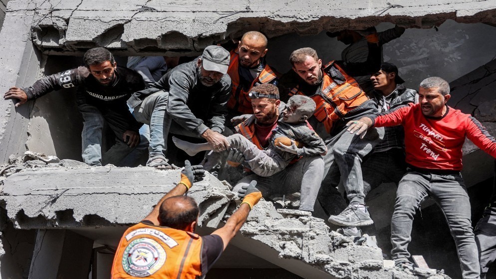 أفراد الدفاع المدني الفلسطيني يخرجون طفلا تم إنقاذه بعد قصف إسرائيلي على منزل عائلة شمالي مدينة غزة .26 تشرين الأول 2024 .(ا ف ب)