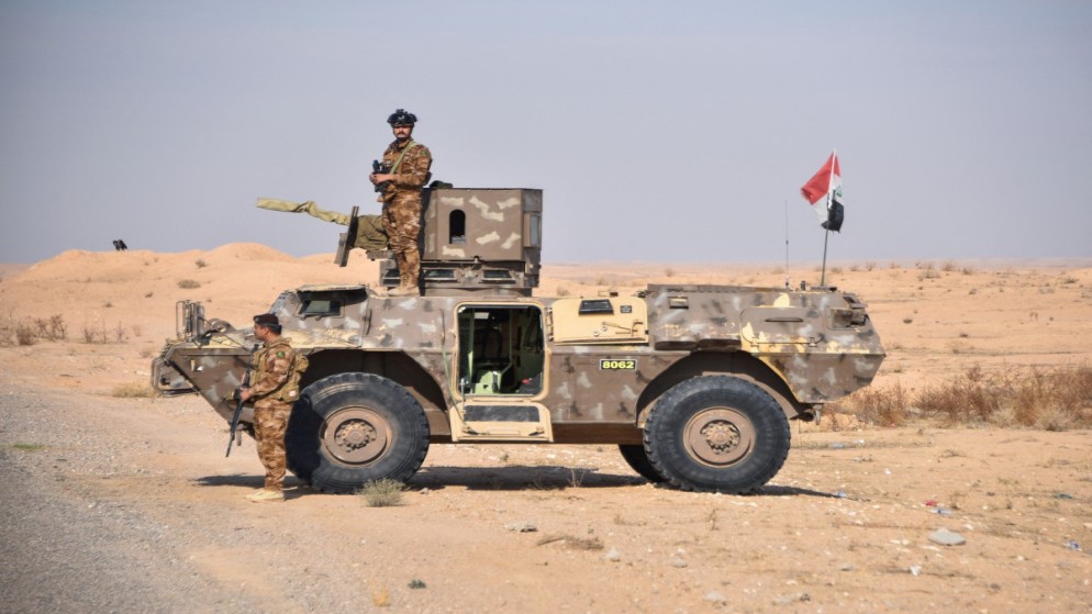 أفراد قوة مشتركة من الحشد الشعبي والجيش العراقي يقفون حراسة على الحدود العراقية السورية، 5 كانون الأول 2024، (أ ف ب)