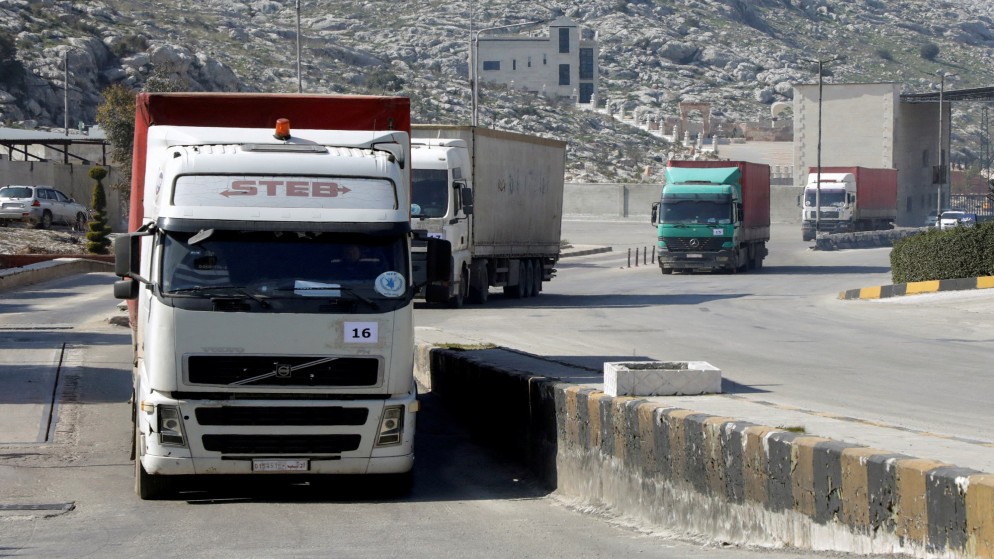شاحنات تحمل مساعدات من برنامج الأغذية العالمي تدخل إلى سوريا عبر معبر باب الهوى. (رويترز)