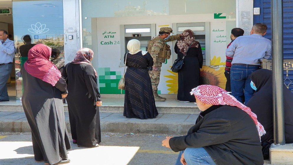 صورة أرشيفية للاجئين في الأردن ينتظرون سحب مساعداتهم النقدية من الصراف الآلي. (المفوضية السامية للأمم المتحدة لشؤون اللاجئين)