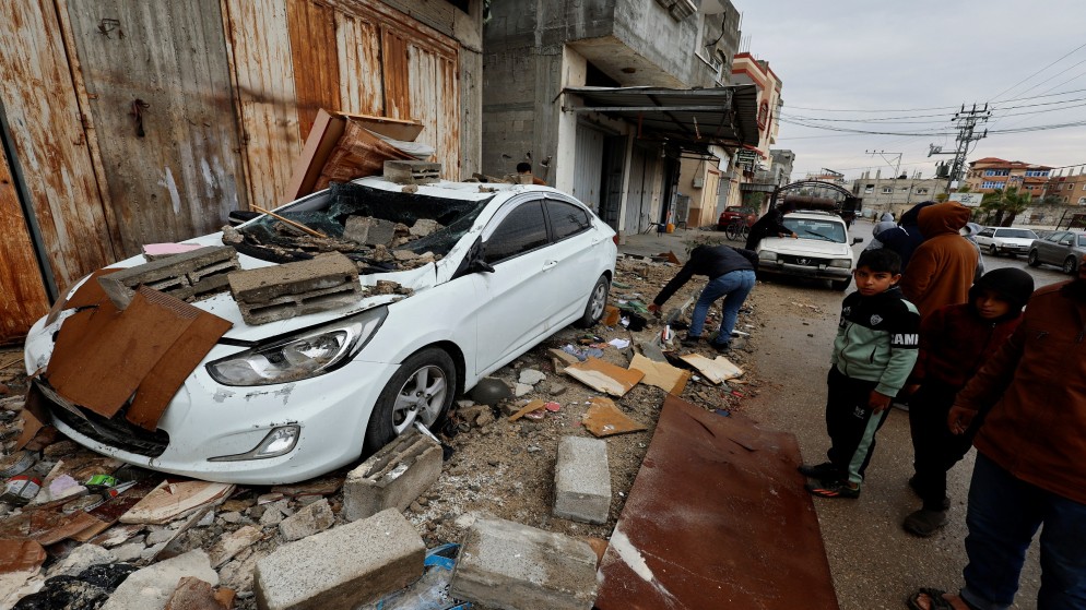 فلسطينيون يتفقدون موقع غارة إسرائيلية على منزل في رفح، جنوبي قطاع غزة، 19 آذار/ مارس، 2024. (رويترز)