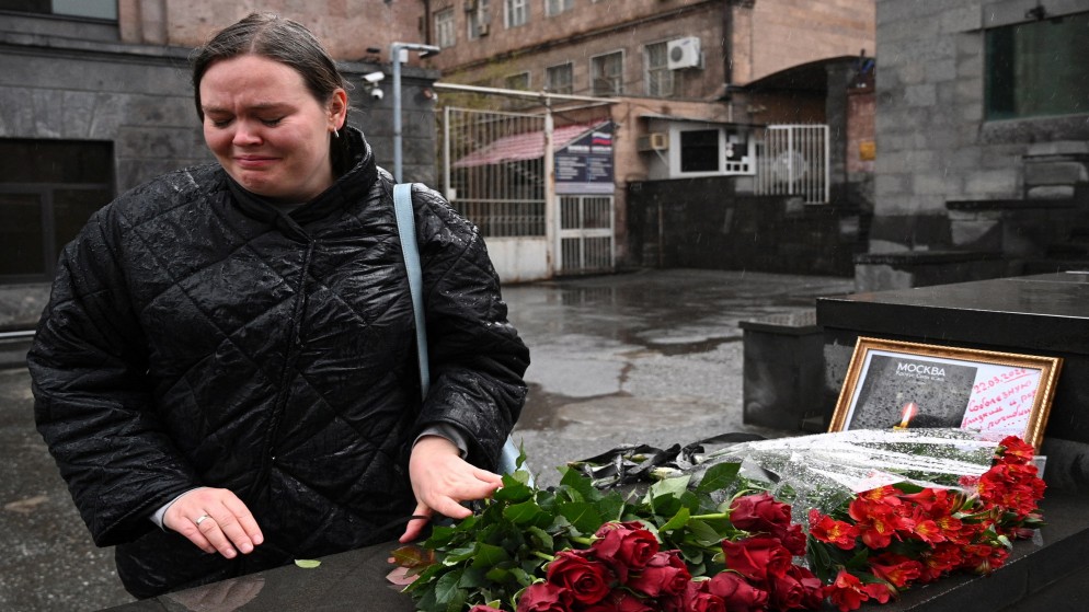 امرأة تبكي عند نصب تذكاري مؤقت أمام السفارة الروسية في يريفان بعد يوم واحد من هجوم مسلح على قاعة مدينة كروكوس في كراسنوجورسك الروسية. .23 مارس 2024،(أ  ف ب)