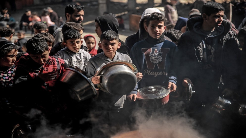 تجمع لأطفال فلسطينيين في انتظار الحصول على طعام مطبوخ في بيت لاهيا شمالي قطاع غزة. (أ ف ب)