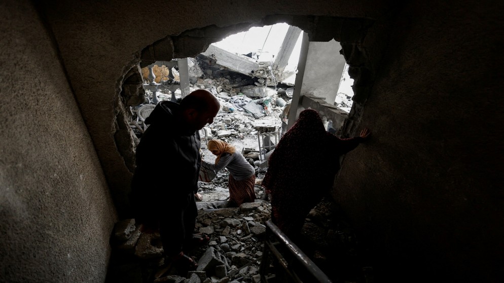 فلسطينيون في موقع غارة إسرائيلية على منزل في رفح جنوبي قطاع غزة، 24 آذار/مارس 2024. (رويترز)