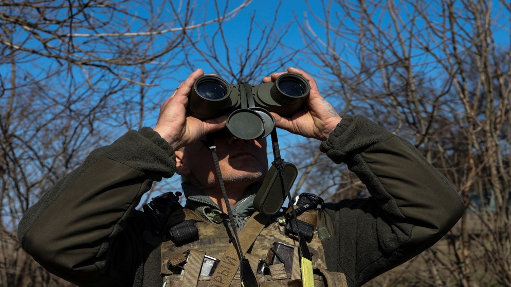 جندي أوكراني يراقب السماء خشية من وقوع هجوم جوي روسي. (رويترز)
