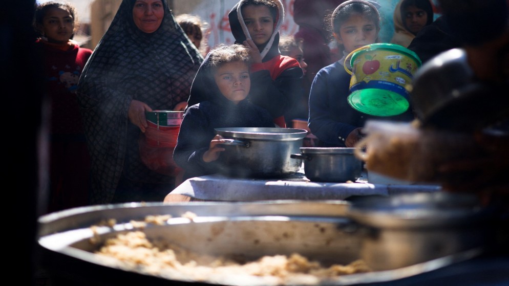 فلسطينيون ينتظرون طعاما مطبوخا في قطاع غزة. (رويترز)
