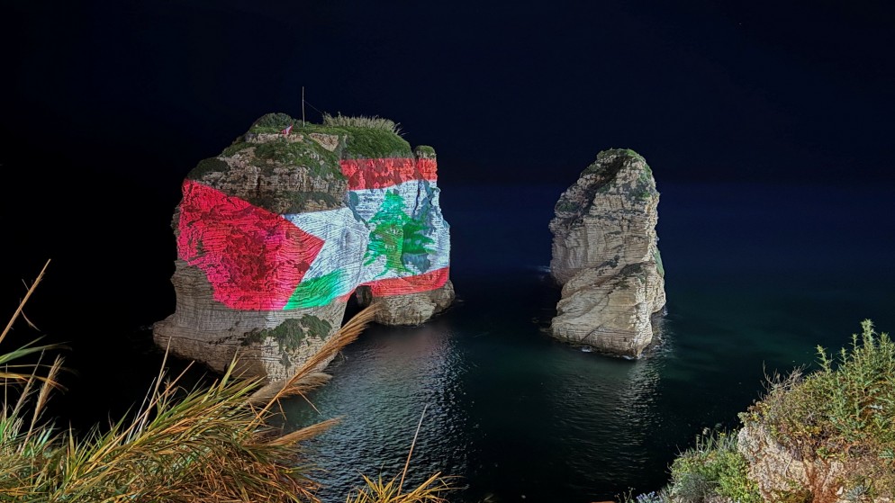 صخرة الروشة في بيروت مضاءة بالعلمين الفلسطيني، 5 نيسان/أبريل 2024. (رويترز)