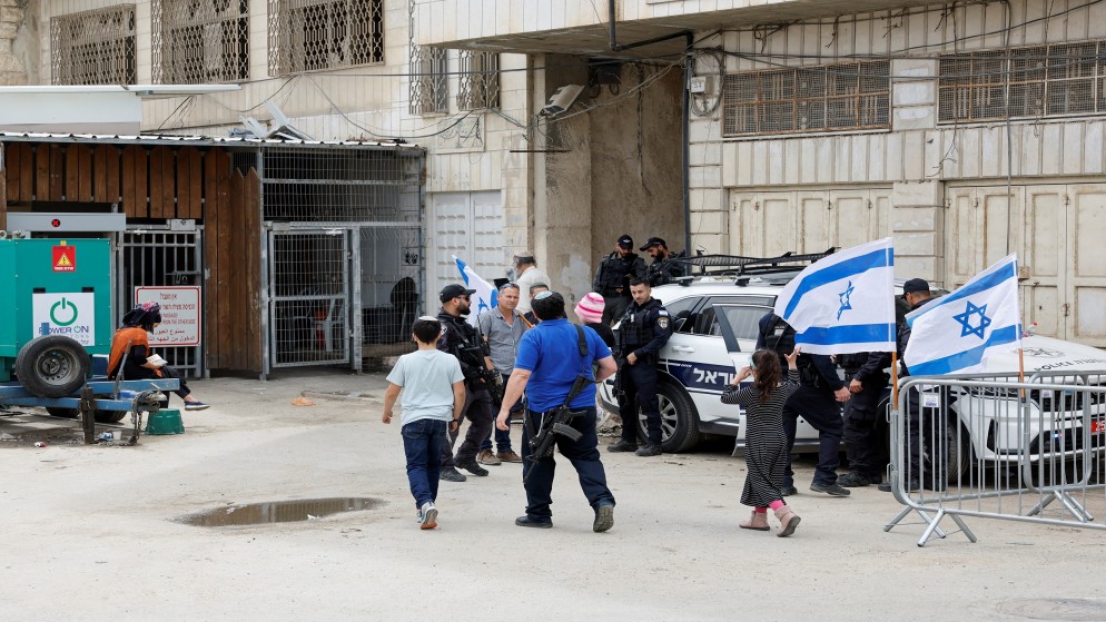مستوطن مسلح عند نقطة تفتيش إسرائيلية قرب الحرم الإبراهيمي في الخليل في الضفة الغربية المحتلة. (رويترز)