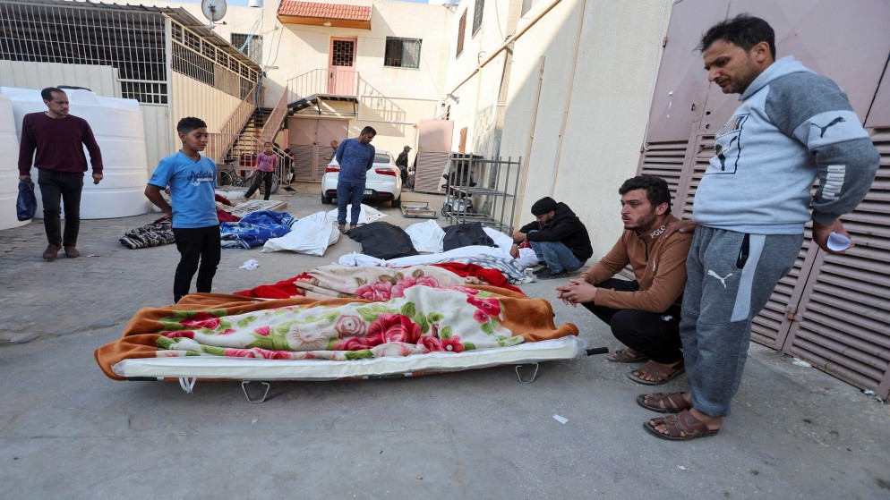 فلسطينيين بجوار جثث الشهداء، في مستشفى الأقصى في دير البلح بوسط قطاع غزة، 14 أبريل 2024. (رويترز)